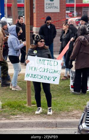 Vaughan, Canada - Apr 25, 2021: Donna che tiene unito il segno di non-conformità in protesta delle misure di arresto COVID-19 in Ontario Foto Stock