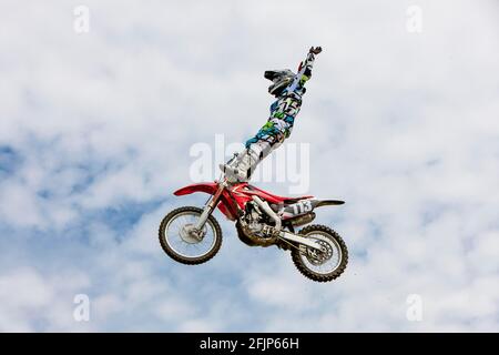 Pilota di motocross che salta di fronte al cielo nuvoloso, Biberach, Baden-Wuerttemberg, Germania Foto Stock