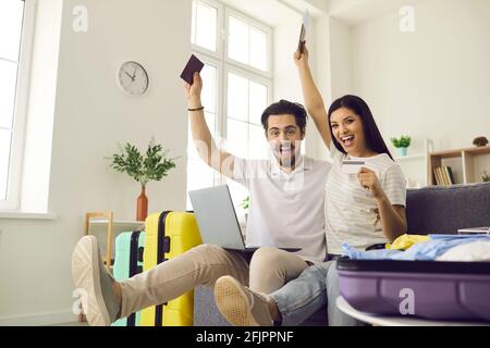 Felice coppia con biglietti e valigie pronti per il viaggio di vacanza divertirsi a casa Foto Stock