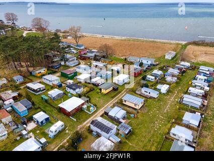 Pepelow, Germania. 22 Apr 2021. Carovane e tende di camper permanenti si trovano sul sito di Ostseecamping 'Am Salzhoff'. (Foto aerea con un drone) a causa delle misure di protezione Corona, i campeggi nel Meclemburgo-Vorpommern sono attualmente chiusi, anche i campeggiatori permanenti non sono autorizzati a pernottare nelle loro roulotte o tende. Credit: Jens Büttner/dpa-Zentralbild/dpa/Alamy Live News Foto Stock