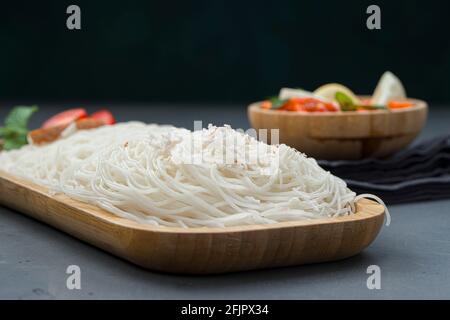 Ideyappam o noolappam, prodotto per la colazione dell'India del sud fatto usando riso crudo che è disposto in una base di servire di legno con uovo masala come buona combinazione Foto Stock