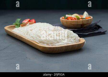 Ideyappam o noolappam, prodotto per la colazione dell'India del sud fatto usando riso crudo che è disposto in una base di servire di legno con uovo masala come buona combinazione Foto Stock