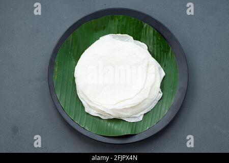 Bel pathiri sud indiano malabar cibo speciale fatto con riso farina che è bianco rotondo sottile cibo cotto disposto tradizionalmente su piastra nera rivestita Foto Stock