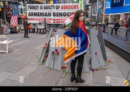 Linda Khalatyan si trova avvolto nella bandiera armena, mentre gli armeni si sono riuniti a Times Square per commemorare il 106esimo anniversario del genocidio armeno del 1915 il 25 aprile 2021 a New York City. L'evento di commemorazione, normalmente grande, è stato notevolmente ridotto e senza relatori ospiti a causa delle restrizioni del Covid-19. La giornata è stata segnata da bandiere armene e da richieste di responsabilità. Il riconoscimento del genocidio armeno da parte del presidente Joe Biden è stato accolto sabato con soddisfazione temperata da parte della Diaspora americana della nazione, con alcuni che affermano che le parole devono portare a maggiori pressioni contro la Turchia. (Foto di Foto Stock