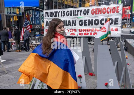 Linda Khalatyan si trova avvolto nella bandiera armena, mentre gli armeni si sono riuniti a Times Square per commemorare il 106esimo anniversario del genocidio armeno del 1915 il 25 aprile 2021 a New York City. L'evento di commemorazione, normalmente grande, è stato notevolmente ridotto e senza relatori ospiti a causa delle restrizioni del Covid-19. La giornata è stata segnata da bandiere armene e da richieste di responsabilità. Il riconoscimento del genocidio armeno da parte del presidente Joe Biden è stato accolto sabato con soddisfazione temperata da parte della Diaspora americana della nazione, con alcuni che affermano che le parole devono portare a maggiori pressioni contro la Turchia. (Foto di Foto Stock