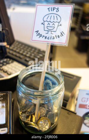 Punta il vaso con le monete sul banco del ristorante Foto Stock