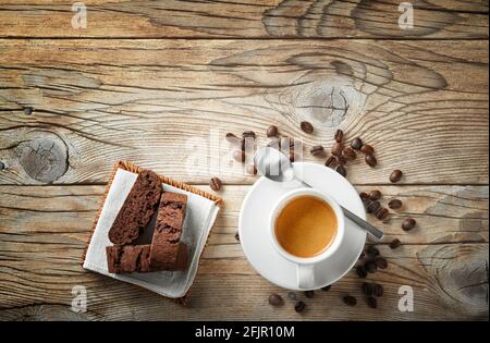 Tazza espresso, biscotti e chicchi di caffè su sfondo in legno, vista dall'alto, spazio per il testo. Foto Stock