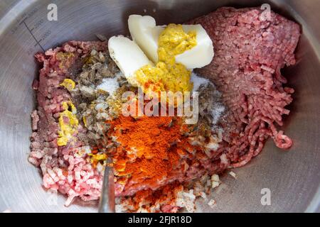 Tutti gli ingredienti per gli hamburger fatti in casa sono insieme e pronti per essere mescolati. Foto Stock