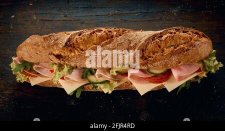 Angolo di panino fresco saporito fatto di pane e. verdure con fette di prosciutto e formaggio su legno rustico tabella Foto Stock