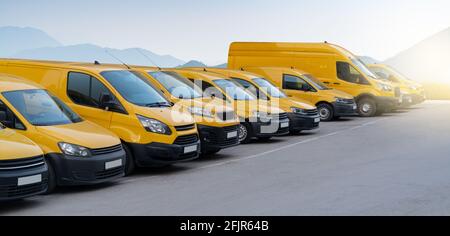 Furgoni di consegna gialli parcheggiati di fila Foto Stock