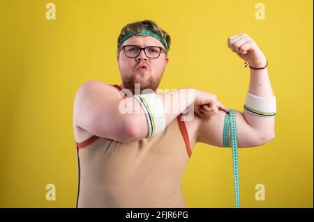 il concetto di uno stile di vita sano. L'uomo sovrappeso misura i parametri del corpo Foto Stock