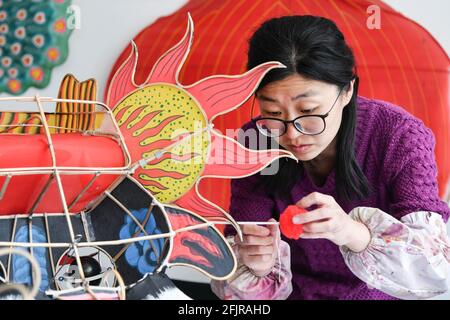 (210426) -- JINAN, 26 aprile 2021 (Xinhua) -- Xu Yang, nipote di Yang Hongwei, fa un aquilone nel villaggio di Yangjiabu, città di Weifang della provincia di Shandong della Cina orientale, 16 aprile 2021. Yang Hongwei, nata in una famiglia di kite a Yangjiabu, ha intrapreso il suo viaggio di fare aquiloni nel 1982 sotto la guida del nonno. Nei successivi quasi 40 anni, Yang ha sviluppato l'eredità culturale e ha vinto le sue opere molti riconoscimenti. Come maestro di kite-making, è stata anche invitata in altri paesi, tra cui Germania, Australia, Stati Uniti e Nuova Zelanda, per promuovere la cultura kite An Foto Stock