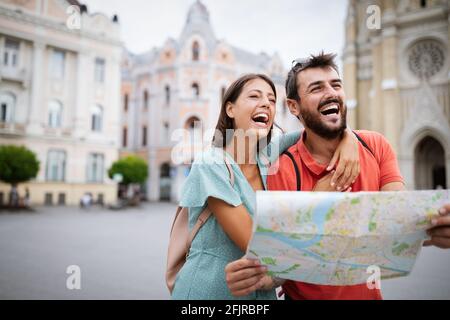 Vacanze estive, datazione e concetto di turismo. Sorridente coppia a piedi con mappa in città Foto Stock