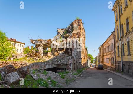 Vecchie case distrutte di mattoni con finestre, adirate di piante sulla città di strada Foto Stock