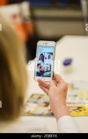 Bad Kreuznach, Germania. 21 Apr 2021. Un cliente riceve consigli dal vivo da Claudia Holbach (in esposizione), amministratore delegato di 'Schuhhaus Wagner'. Il negozio di calzature 'Schuhhaus Wagner' offre ai suoi clienti video shopping dal vivo. I clienti camminano in diretta attraverso la sala vendite con consigli di esperti tramite un'app e ricevono consigli individuali. (A dpa: 'Video-Shopping: Scegliere le scarpe da andare con il tuo vestito sul divano a casa') Credit: Andreas Arnold/dpa/Alamy Live News Foto Stock