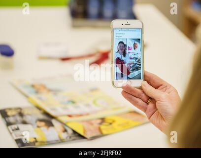 Bad Kreuznach, Germania. 21 Apr 2021. Un cliente riceve consigli dal vivo da Claudia Holbach (in esposizione), amministratore delegato di 'Schuhhaus Wagner'. Il negozio di calzature 'Schuhhaus Wagner' offre ai suoi clienti video shopping dal vivo. I clienti camminano in diretta attraverso la sala vendite con consigli di esperti tramite un'app e ricevono consigli individuali. (A dpa: 'Video-Shopping: Scegliere le scarpe da andare con il tuo vestito sul divano a casa') Credit: Andreas Arnold/dpa/Alamy Live News Foto Stock