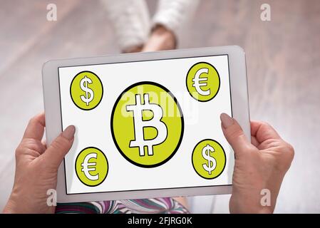 Il concetto di Bitcoin mostrato su un tablet tenuto da una donna Foto Stock