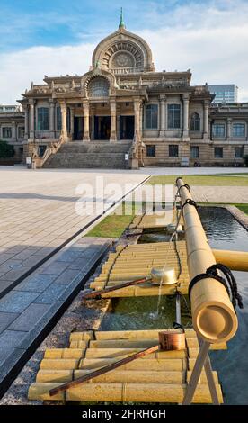 Il padiglione di abluizione dell'acqua per la purificazione cerimoniale (Chozuya o temizuya) di fronte al tempio buddista di Tsukiji Hongan-ji. Tokyo, Giappone Foto Stock