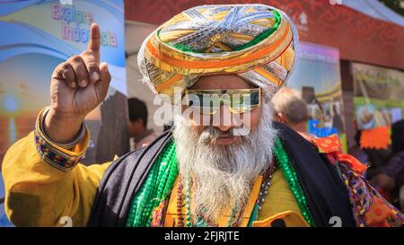 Sikh Punjabi uomo Kala Kala in colorato Dastar Turban e vibrante abito tradizionale, sorridente, si pone a un festival asiatico su Trafalgar Square, Londra Foto Stock