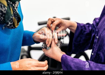 Donna non riconosciuta che misura la dimensione dell'anello in officina di gioielleria. Foto Stock