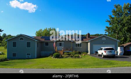 MIDDLETOWN, NY, STATI UNITI - Jul 14, 2020: Suburban Solar Pannel Casa Ranch stile Casa con auto in vialetto, Immobiliare, tecnologia verde casa, e Foto Stock