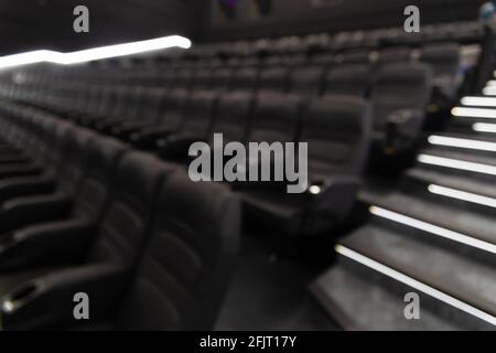 Immagine sfocata dei sedili in pelle nera vuoti nel cinema - immagine di sfondo divertente e di intrattenimento Foto Stock