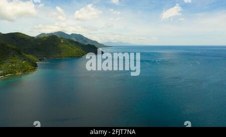 Drone aereo della costa dell'isola di Leyte con colline e montagne coperte di verde foresta e giungla. Filippine. Foto Stock