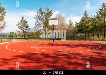 Un campo da pallacanestro vuoto trovato all'aperto durante la primavera stagione Foto Stock