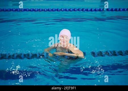 Felice donna di mezza età in piscina. Foto Stock
