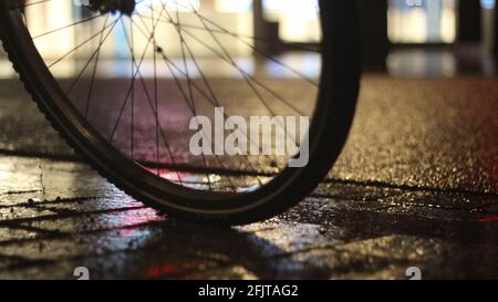 Primo piano di una ruota di bicicletta in una giornata piovosa di notte Foto Stock