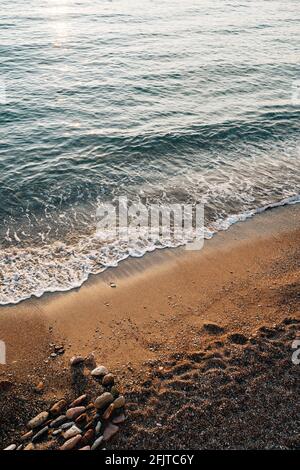 Alesaggio corrente. L'onda scorre sulla spiaggia dove si trovano le pietre Foto Stock