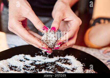 Fare dolci sani senza zucchero da frutta secca e fiocchi di cocco a casa. Primo piano. Messa a fuoco selettiva Foto Stock