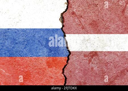 Bandiere di Russia e Lettonia dipinte su sfondo di parete fessurato - la politica contrasta il concetto Foto Stock