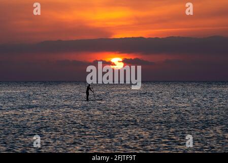 Sali a paddle-boarding nei Caraibi al tramonto Foto Stock