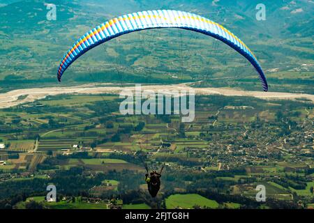 Panorama della valle dal rifugio ere. I primi momenti del volo di un parapendio. San Gregorio nelle Alpi, Belluno, Italia Foto Stock