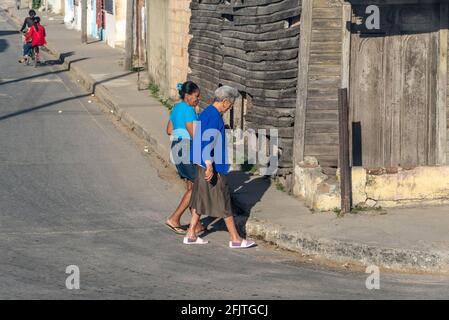 Due donne cubane che camminano in giù casa in un piccola città Foto Stock