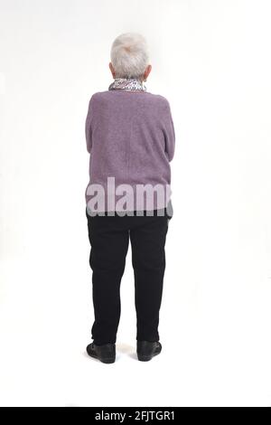 vista posteriore della donna anziana con le braccia incrociate su bianco sfondo Foto Stock