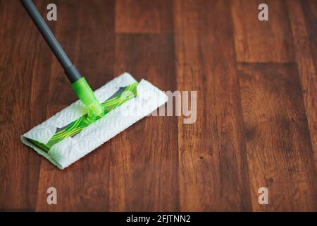 Tempo della famiglia. Primo piano su mop e pavimento in casa moderna Foto Stock