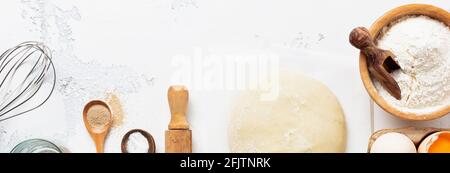 Sfondo di cottura con impasto e ingredienti per la preparazione di pasta o frittelle, uova, farina, acqua e sale su tavola bianca rustica. Vista dall'alto Foto Stock