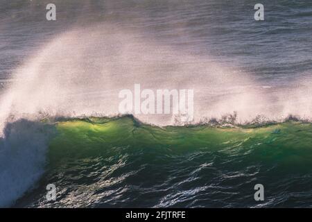 Spray soffiato dalla cresta di un'onda da forte vento offshore sulla costa nord della Cornovaglia. Foto Stock