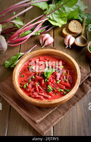 Zuppa tradizionale ucraina russa (borscht) con verdure e panna acida su tavolo di legno Foto Stock