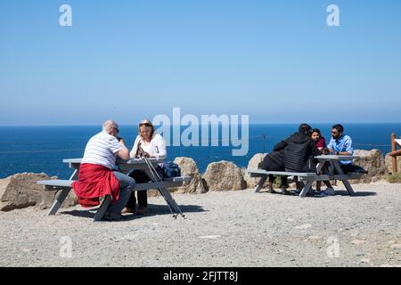 Land's End, Cornovaglia, Regno Unito, 26 aprile 2021, le persone si sono goduti la vista incredibile e il glorioso sole sulla fine di Land in Cornovaglia. I venti forti si sono attenuati dopo i venti raffrontati nel fine settimana. I visitatori hanno cenato all'Alfresco e hanno anche gustato un gelato.Credit: Keith Larby/Alamy Live News Foto Stock