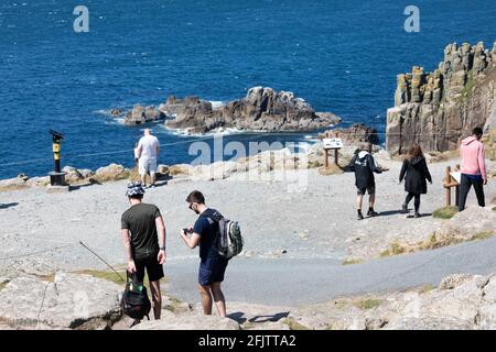 Land's End, Cornovaglia, Regno Unito, 26 aprile 2021, le persone si sono goduti la vista incredibile e il glorioso sole sulla fine di Land in Cornovaglia. I venti forti si sono attenuati dopo i venti raffrontati nel fine settimana. I visitatori hanno cenato all'Alfresco e hanno anche gustato un gelato.Credit: Keith Larby/Alamy Live News Foto Stock