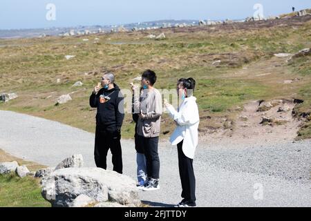 Land's End, Cornovaglia, Regno Unito, 26 aprile 2021, le persone si sono goduti la vista incredibile e il glorioso sole sulla fine di Land in Cornovaglia. I venti forti si sono attenuati dopo i venti raffrontati nel fine settimana. I visitatori hanno cenato all'Alfresco e hanno anche gustato un gelato.Credit: Keith Larby/Alamy Live News Foto Stock