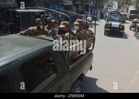 Pakistan esercito, ranger truppe pattugliano in un mercato, bazar, strade principali per osservare le nuove restrizioni annunciate dal governo per la comunità imprenditoriale di controllare la diffusione del coronavirus, a Lahore, Pakistan il 26 aprile 2021. Le autorità pakistane stanno correndo contro il tempo per aggiungere più letti e ventilatori agli ospedali in mezzo a un aumento dei decessi e delle infezioni da coronavirus. Secondo il ministro degli interni Sheikh Rashid Ahmad, le autorità hanno iniziato a convocare truppe per garantire che le persone non violino le regole di allontanamento sociale. (Foto di Rana Sajid Hussain/Pacific Press/Sipa USA) Foto Stock