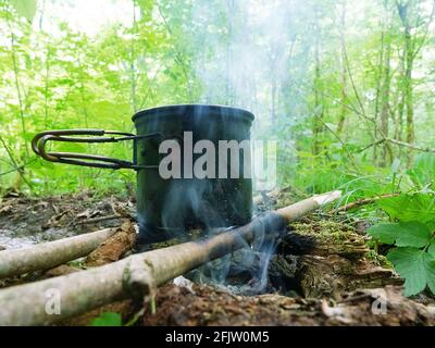 Cucina campo. Cucina sul fuoco durante l'escursione. Pentola appesa al fuoco Foto Stock