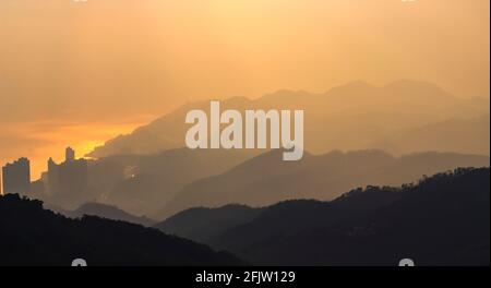 Strati di montagne nascoste nella nebbia a Hong Kong. Foto Stock