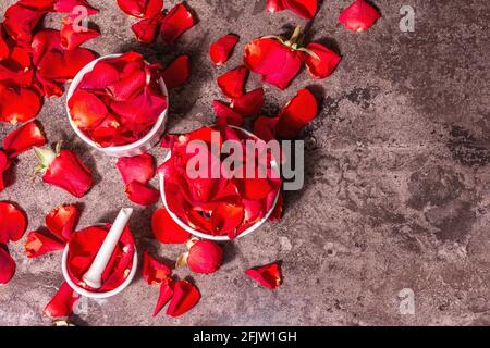 Rosewater con petali di rosa. Fare essenza di rosa organica per cucinare Kerala India. Olio essenziale, aromaterapia, relax spa, concetto di cosmetica. Modalità Foto Stock