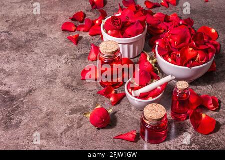 Rosewater con petali di rosa. Fare essenza di rosa organica per cucinare Kerala India. Aromaterapia, relax spa, concetto cosmetico. Luce moderna, Foto Stock