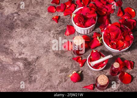 Rosewater con petali di rosa. Fare essenza di rosa organica per cucinare Kerala India. Aromaterapia, relax spa, concetto cosmetico. Luce moderna, Foto Stock